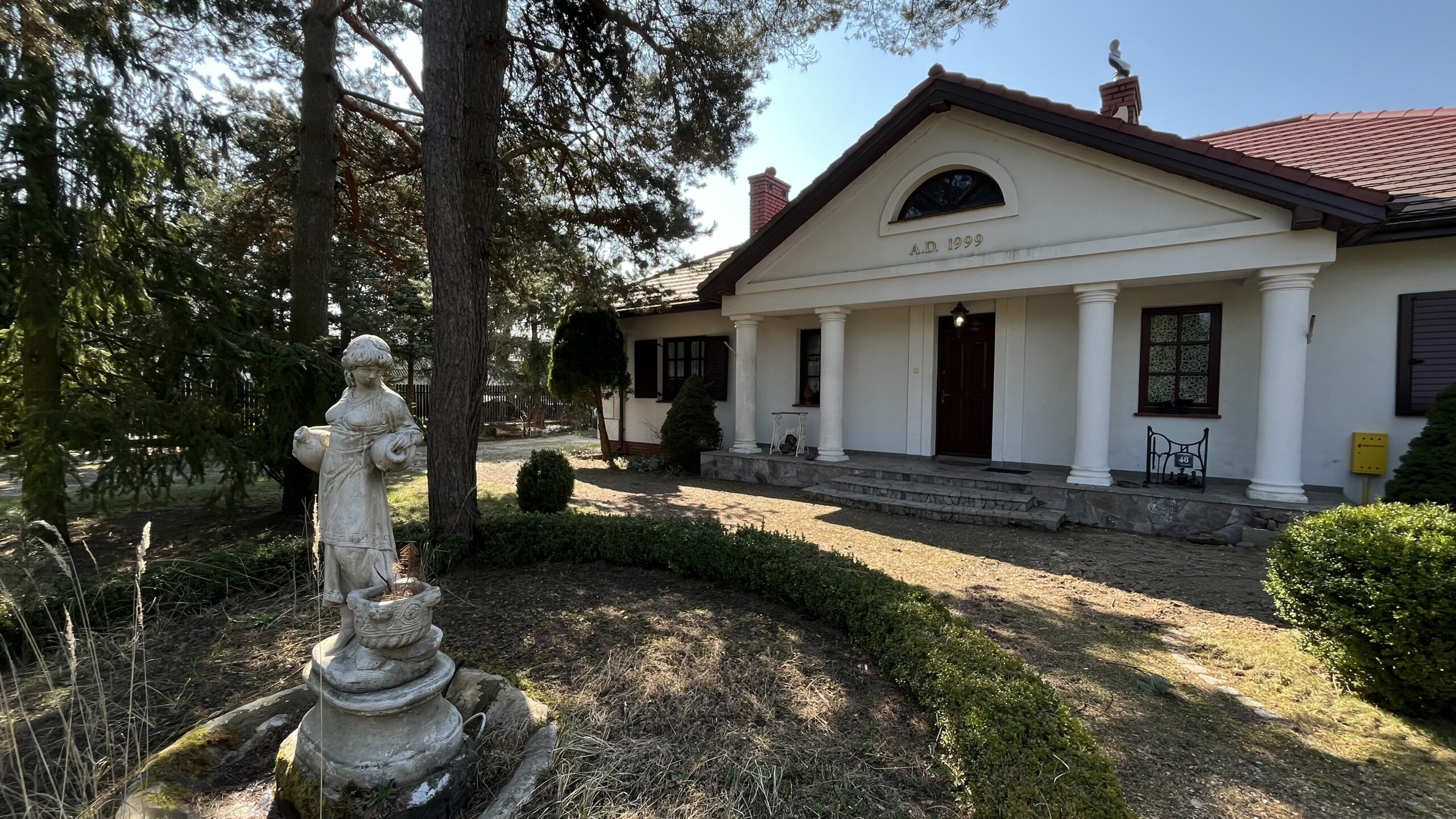 Front domu Siedlisko Studzianki pośród drzew